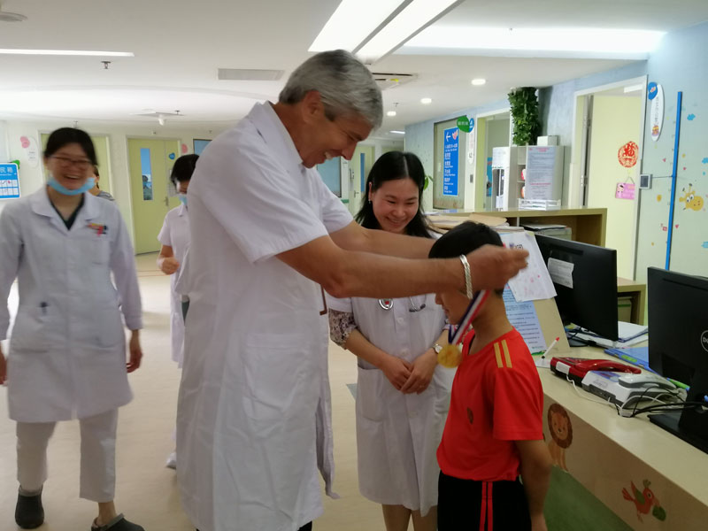 1662141896053000139.jpg 47多伦多病童医院Eric-Bouffet教授为治愈的病患儿带上奖牌(图片由深圳市儿童医院提供).jpg